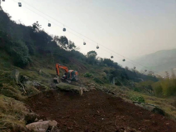 挖掘機在山坡上作業。周洪攝