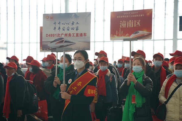 重慶西站工作人員舉牌引導外出務工人員有序上車。魏偉攝