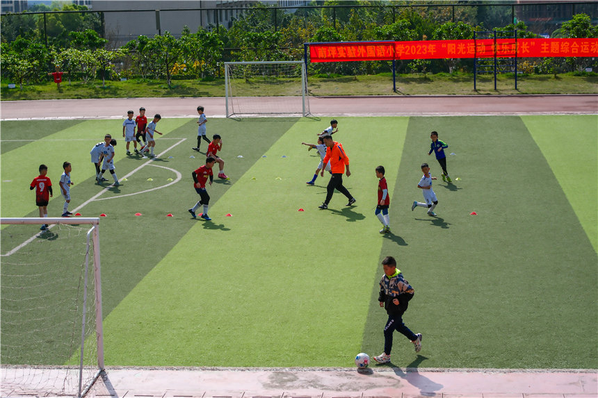 課后延時班上，足球小將們盡情奔跑在綠茵場。郭旭攝