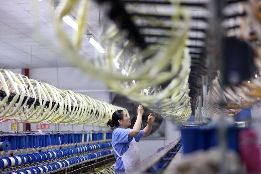 絲綢紡織女工在生產車間忙碌。楊敏攝