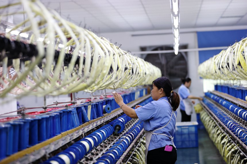 絲綢紡織女工在生產車間忙碌。楊敏攝