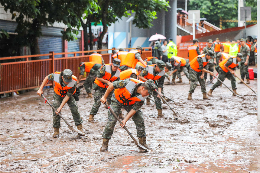 圖為武警官兵清理街道淤泥。李東攝