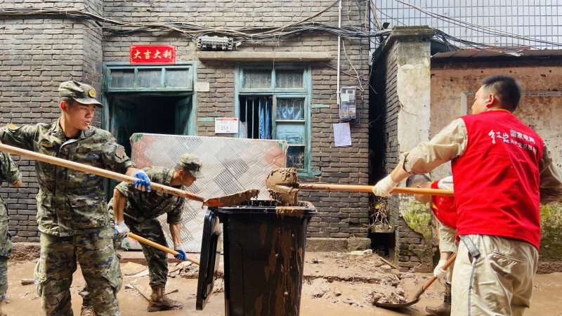 7月7日，國家電網紅巖（萬州營配）共產黨員服務隊與武警官兵同心協力清淤。張釗攝