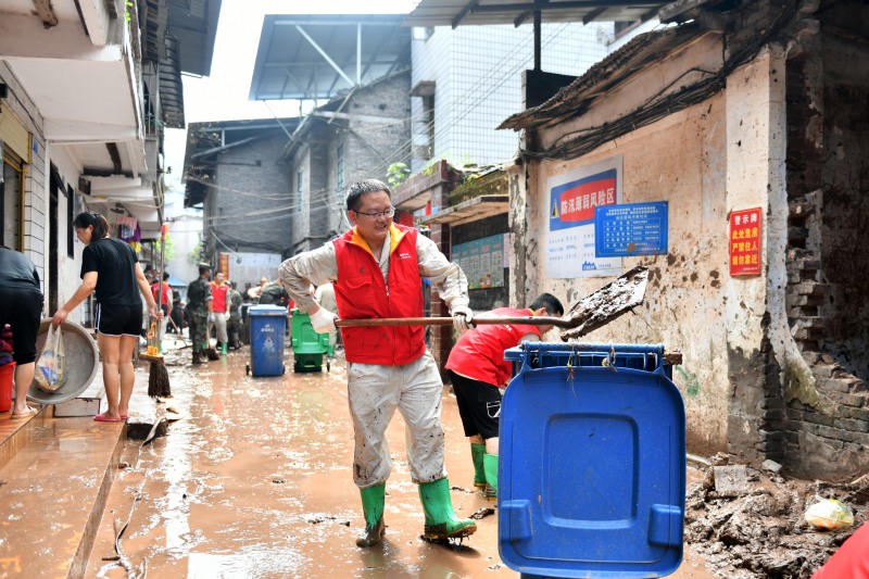 7月7日，國家電網紅巖（萬州營配）共產黨員服務隊隊員清理淤泥。王倩攝