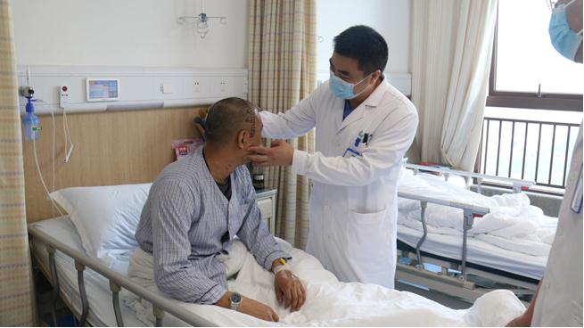 梁鴻查看病人情況。重慶西區醫院供圖