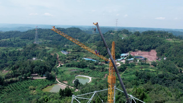 8月6日，位于重慶市潼南區新勝鎮的川渝1000千伏交流特高壓線路工程101號塔，國網重慶市電力公司員工正在進行組塔施工作業。劉洪君攝
