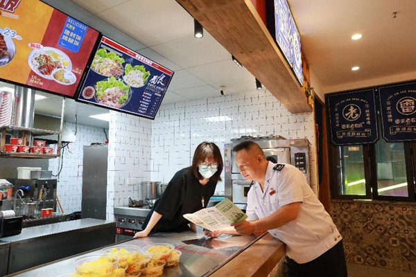 近日，沙坪壩區稅務人員走進酸辣粉店，宣傳個體工商戶相關稅費優惠政策，點對點答疑解難。陳賽亞攝