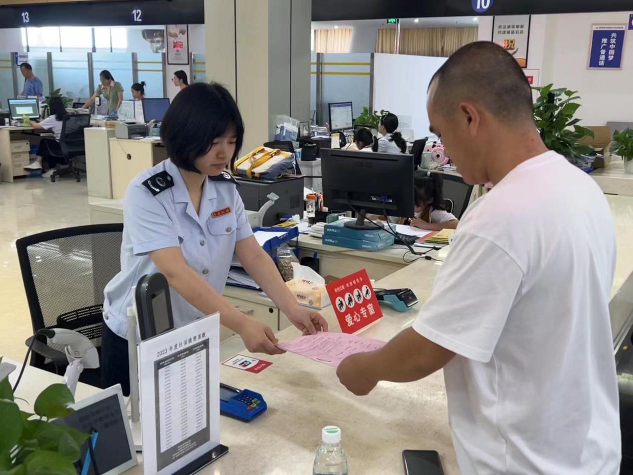 在大足區辦稅服務廳，愛心專窗稅務人員正在為殘疾人士辦理涉稅業務。蔣寧澤攝