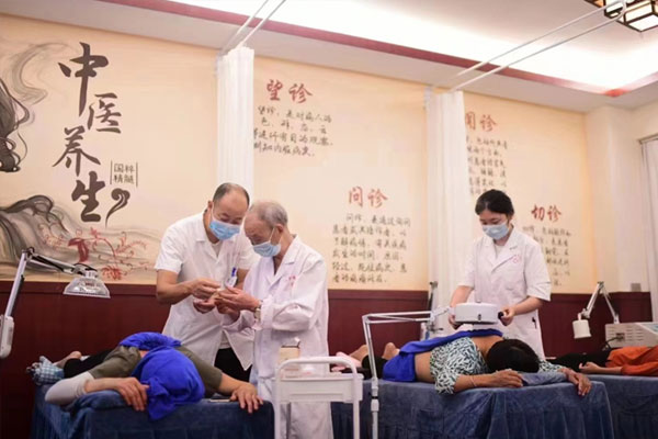 曾維彬（左一）為患者提供針灸理療服務。璧山區福祿鎮衛生院供圖