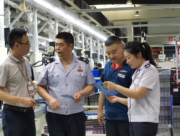 在重慶隆鑫發動機有限公司，高新區稅務局人員宣傳輔導研發費用加計扣除等稅收優惠政策。王玉婷攝