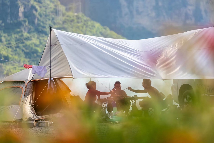 游客在頭渡鎮一露營基地避暑納涼。瞿明斌攝