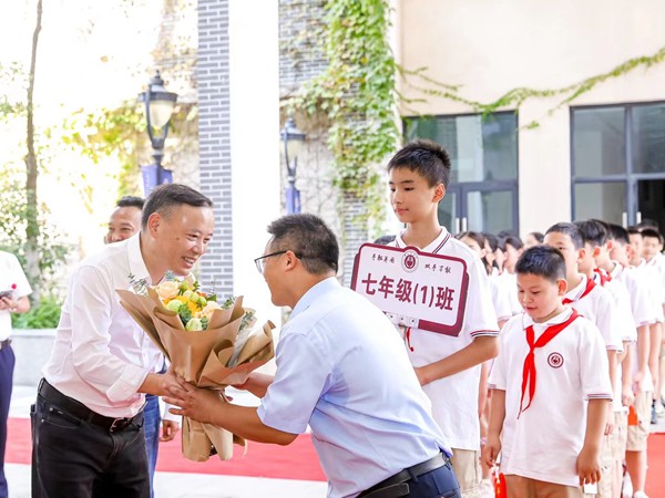 渝北區委教育工委書記、區教委主任吳云斌（左一）與黃炎培中學師生。黃炎培中學供圖