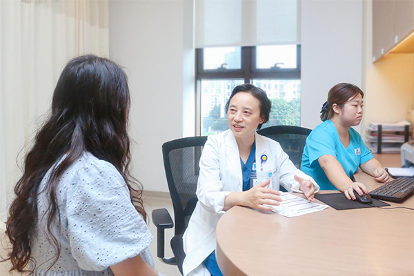 但陽（中）為患者進行診療。重慶安琪兒婦產醫院供圖