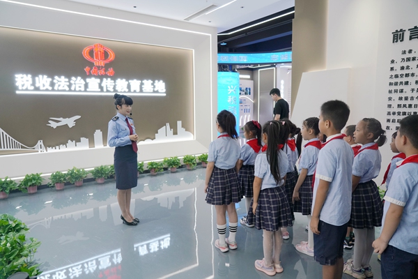 9月13日，在渝北區稅收法治宣傳教育基地，稅務人員給渝北區數據谷小學的同學們講解稅收發展史。紀源攝