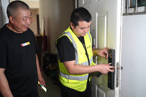 服務團隊為退役老兵何忠明家更換智能鎖。美心集團供圖