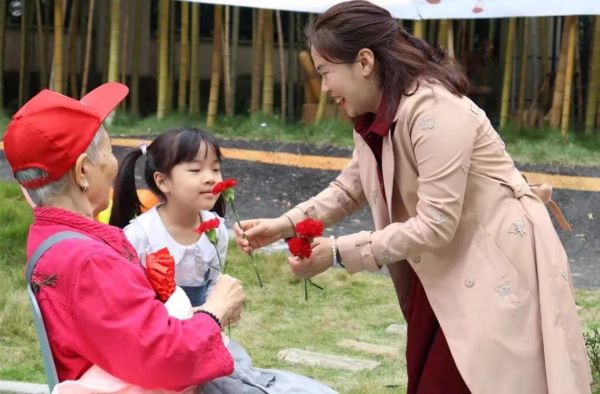 幼兒園小朋友和園長曾莉為老人獻花。新絲路幼兒園供圖