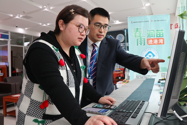 在三峽銀行綦江支行銀行，工作人員輔導市民韓女士網上申報納稅。李奕萱攝