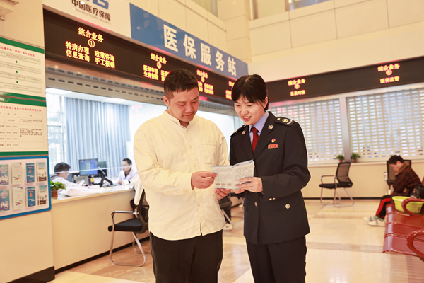 在重慶市第九人民醫院“醫保服務站”，稅務人員正向繳費人宣傳講解醫保繳費政策。楊蔓攝
