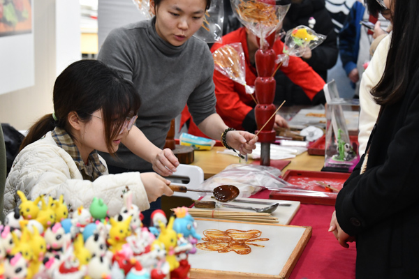 非遺糖畫師指導學生制作糖畫。鄒樂攝