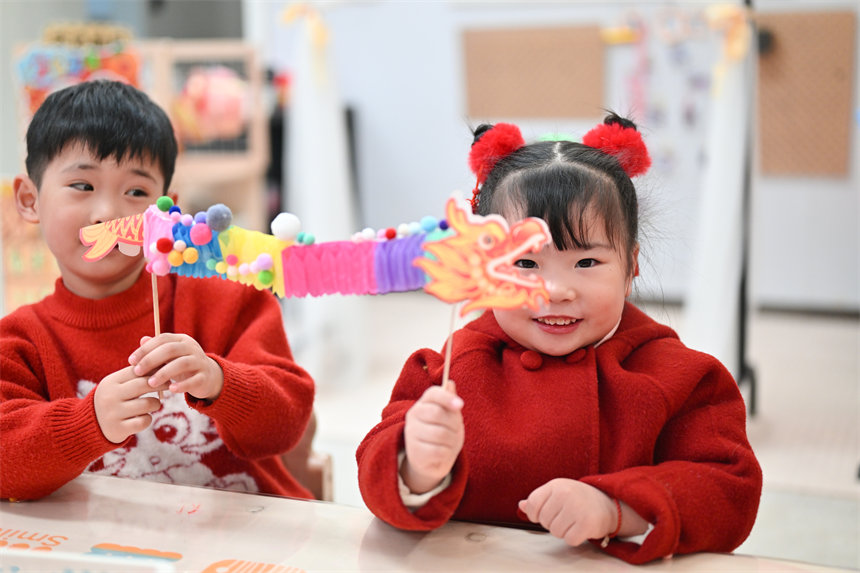 小朋友展示制作的手工翻花龍。郭旭攝