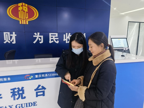 武隆區稅務人員輔導群眾在手機上辦理社保業務。侯東攝