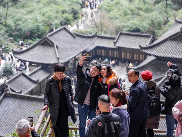 2月14日，在武隆區天生三橋景區天福官驛前，游客們紛紛拍照留念。王俊杰攝