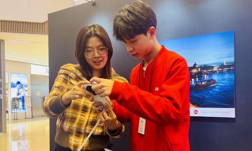 工作人員為市民講解手機AI功能。馬春鵬攝