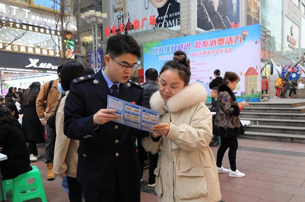 在沙坪壩區國際消費者節宣傳活動上，沙坪壩區稅務人員正在講解發票相關政策。陳賽亞攝
