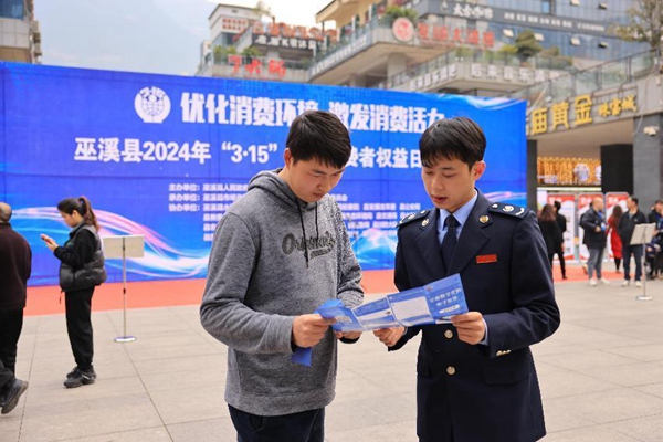 3月15日，在巫溪縣水園商城，稅務人員正為市民講解發票維權相關內容。肖镕攝