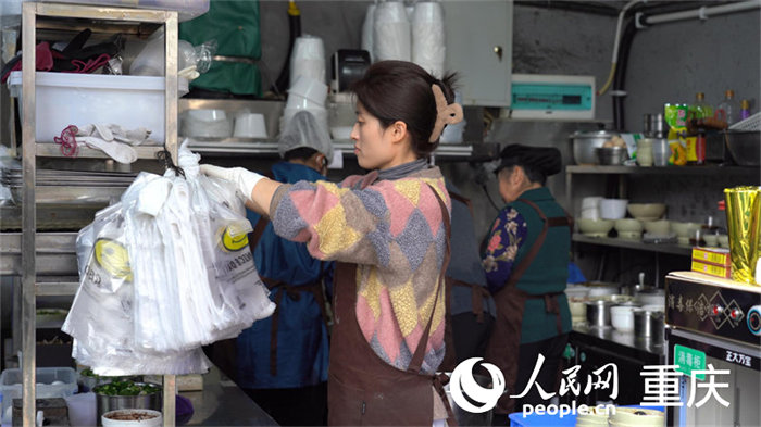 中午時分，店主何女士正在莽著給顧客備餐。人民網 劉祎攝