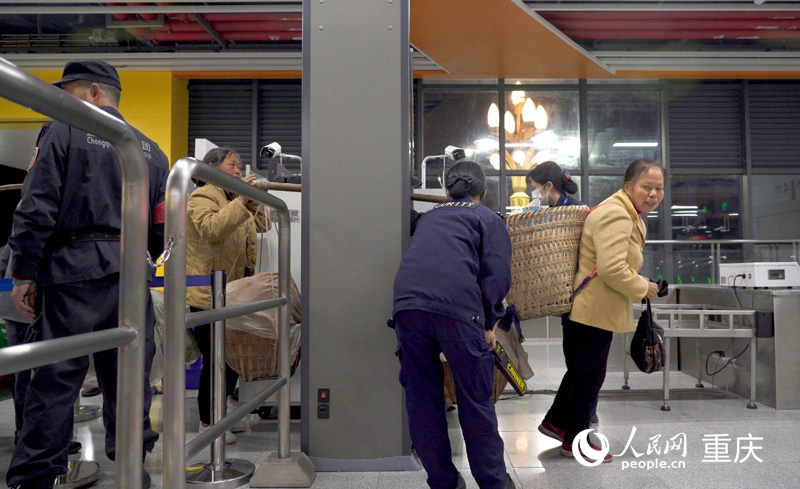 軌道四號線石船站工作人員幫助菜農果農們有序進站。人民網記者 劉祎攝