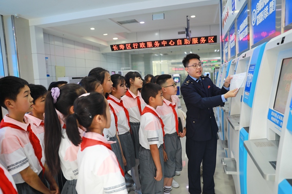在長壽區辦稅服務廳，同學們正認真聽稅務人員講解發票代開機的操作步驟和發票的相關知識。袁洪昊攝