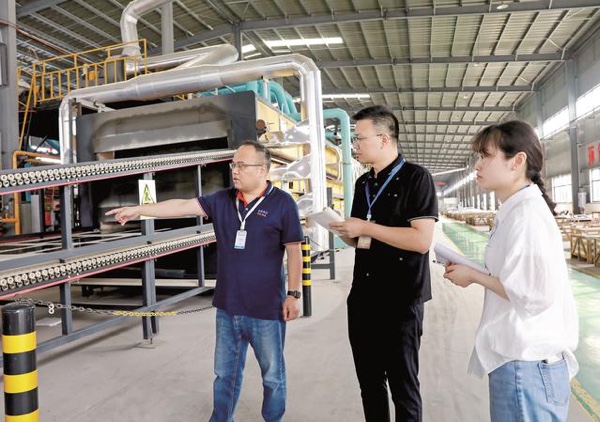 工作人員在企業生產車間，走訪了解企業發展情況。華鎣市融媒體中心供圖