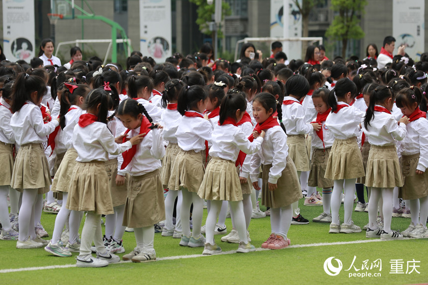 高年級學生為新入隊的少先隊員佩戴紅領巾。人民網記者 劉政寧攝