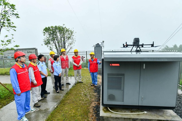 志愿者在特高壓跨江鐵塔處了解無人機自主巡檢情況。王化全攝