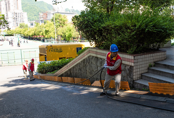 國網城口供電公司員工將發電車電源接入城口中學教學樓。牟丹陽攝