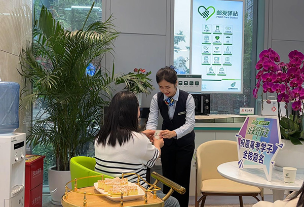 “郵愛驛站”工作人員為送考家長端上熱水。郵儲銀行重慶分行供圖