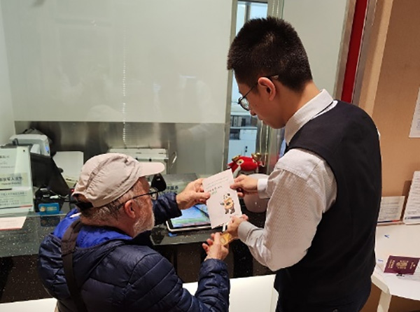 工作人員為外籍來渝人員講解相關業務辦理流程。浦發銀行重慶分行供圖