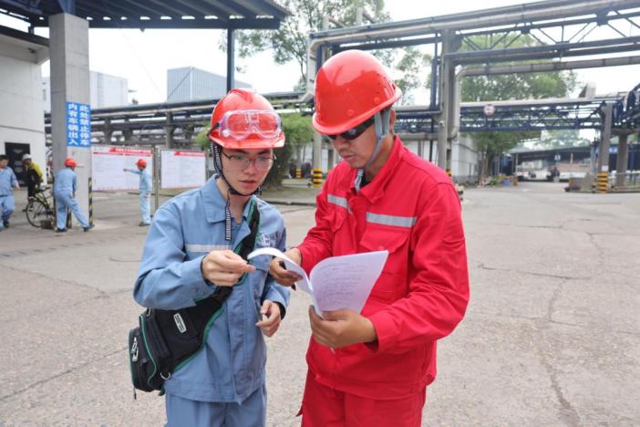 現場作業人員在核對施工方案。川維化工供圖