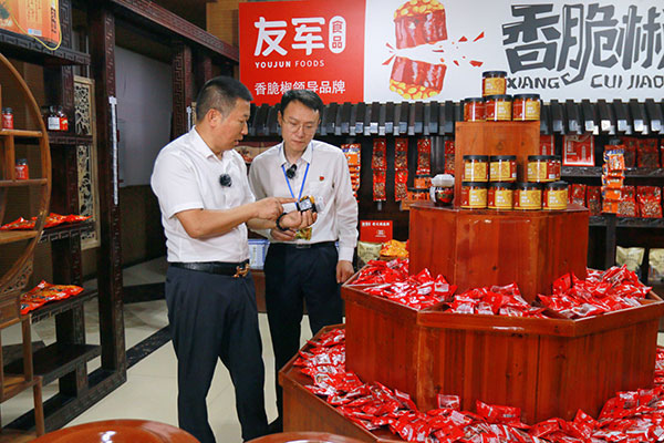 余家友（左）向工行工作人員介紹企業食品。戚馨月 攝