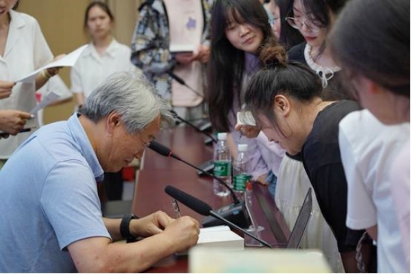 臧棣為師生簽名。重慶人文科技學院供圖