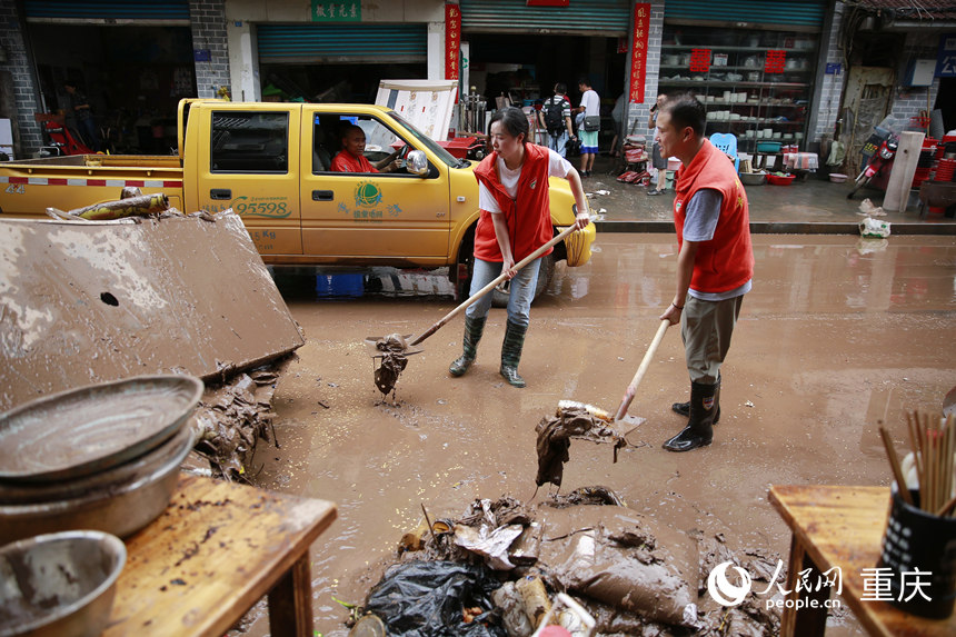 志愿者清理仁沙鎮場鎮的淤泥和雜物。人民網記者 劉政寧攝
