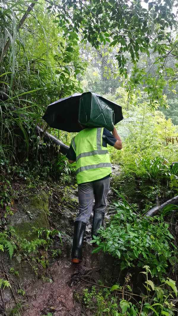 重慶移動墊江分公司網絡人員肩扛保障物資搶修基站。重慶移動供圖