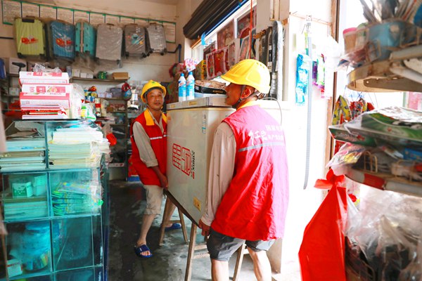 國網重慶永川供電公司員工在榮昌吳家鎮幫助受災群眾搬運冰箱到高處防止觸電事故發生。國網重慶永川供電公司供圖