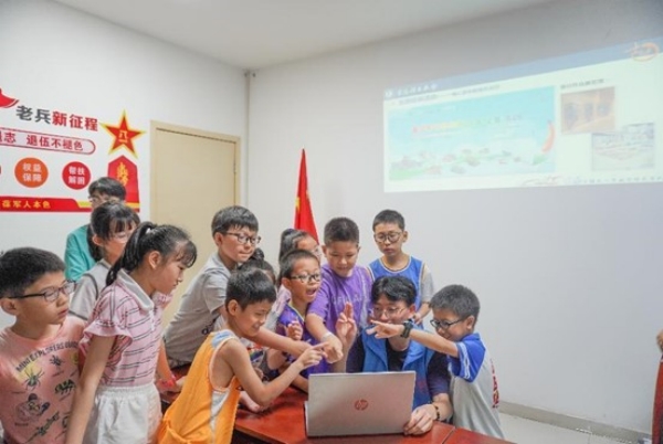 團隊成員指導小朋友進行手勢繪畫。重慶理工大學供圖