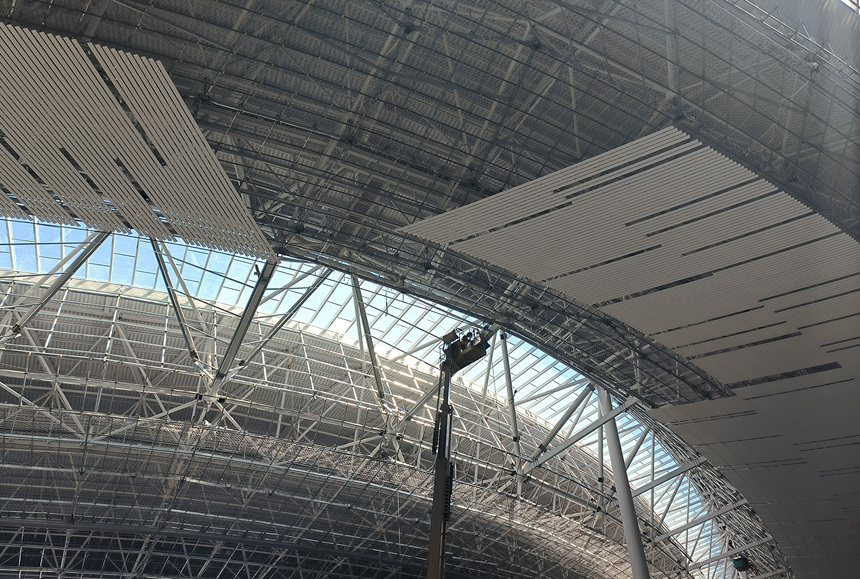 工人師傅正在曲臂車上進行裝飾吊頂作業。建設方供圖