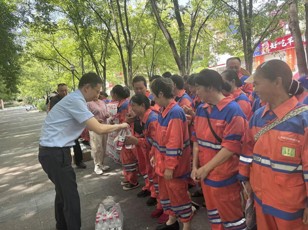 工作人員將清涼飲品送到環衛工人手中。人保財險重慶分公司供圖