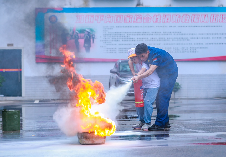 消防員指導小朋友用滅火器救火。梁平區青少年活動中心供圖