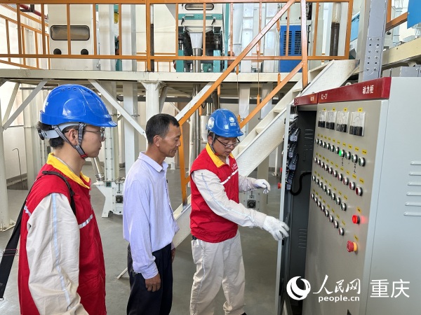 供電所工作人員上門檢查小米加工廠用電情況。人民網記者 劉政寧攝