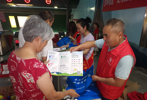 志愿者在小龍坎地鐵站開展垃圾分類宣傳活動。沙坪壩區交通運輸委供圖